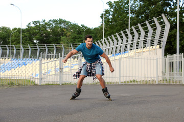 Poster - Handsome young man roller skating outdoors. Recreational activity