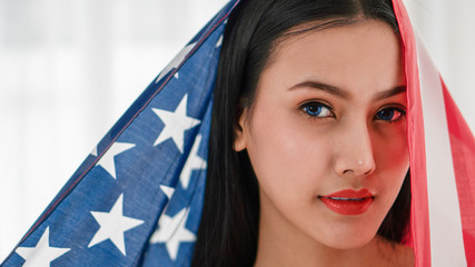 portrait of woman face with blue eyes with American flag on bright background