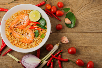 Wall Mural - Instant noodles, spicy shrimp soup, spicy, spicy, with Thai spices placed on an old wooden table.