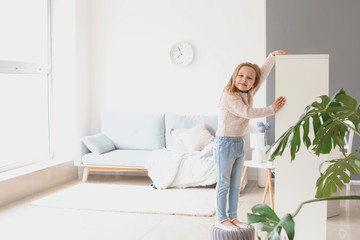 Poster - Cute little girl measuring her height at home