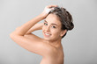 © Pixel-Shot - Beautiful young woman washing hair against grey background