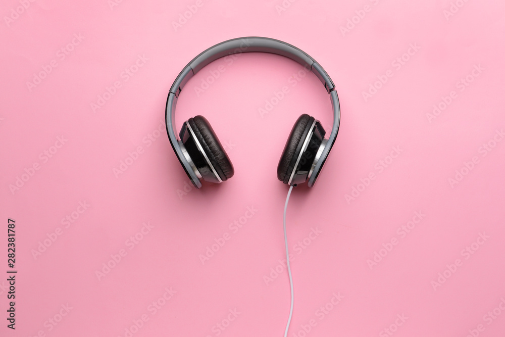 Modern headphones on color background