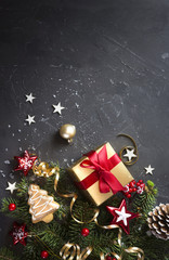 Wall Mural - christmas dark black background with beautiful texture and golden gift box with red ribbon, fir bran