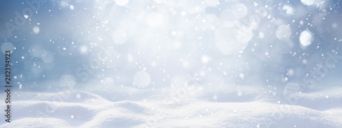 Fotografía Winter snow background with snowdrifts, with beautiful light and snow flakes on the blue sky, beautiful bokeh circles, banner format, copy space