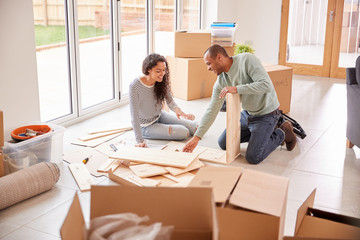 Wall Mural - Couple In New Home On Moving Day Putting Together Self Assembly Furniture