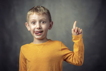 Fototapete - Funny portrait of a 6 year old Caucasian child with his tongue sticking out.