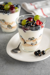 Wall Mural - Tiramisu with berries in glasses on grey background. Italian dessert. Copy space.