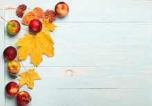 Autumn Yellow Dry Maple Leaves And Red Ripe Apples On A Blue Wooden Background. Flat Layout. Copy Space. Autumn Concept.