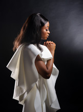Portrait Of A Beautiful Young African Woman In White Dress Over Black Background