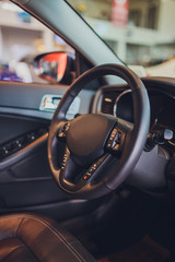 Canvas Print - Dark luxury car Interior - steering wheel, shift lever and dashboard. Car interior luxury. Beige comfortable seats, steering wheel, dashboard, climate control, speedometer, display, light wood panels.