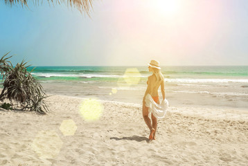 Happy traveller woman in white enjoys her tropical beach vacatio