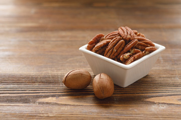 Wall Mural - White square bowl of pecan nuts. Healthy eating concept