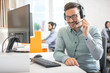 © Bojan - Friendly customer support agent man with headset talking with client in call centre