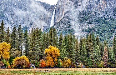 Wall Mural - Yosemite National Park Valley with Yosemite Falls at cloudy autumn morning. Low clouds lay in the valley. California, USA.