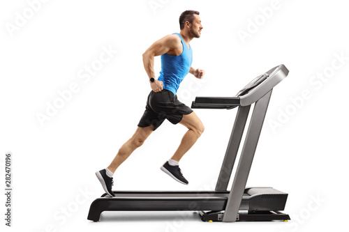 Fotomural Young man in sportswear running on a professional treadmill