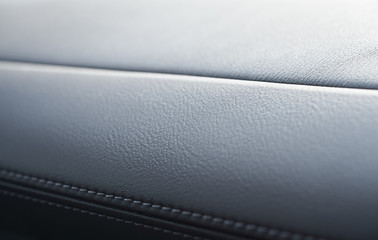 Close up of black leather detail with light and shade of a modern car interior