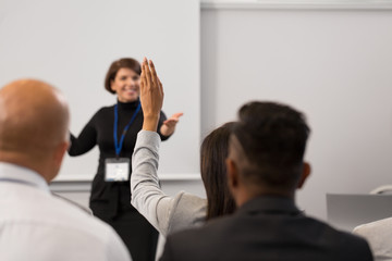 business, education and people concept - smiling businesswoman or teacher answering questions at con