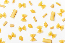 Various Uncooked Pasta On White Background. Top View. Raw Pasta With Ingredients For Cooking. Food Concept