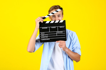 Sticker - Young man with clapper board on yellow background