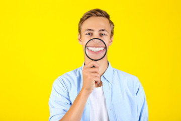 Sticker - Young man with magnifying glass on yellow background