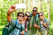 © Syda Productions - travel, tourism, hike and people concept - group of friends with backpacks taking selfie by smartphone in forest