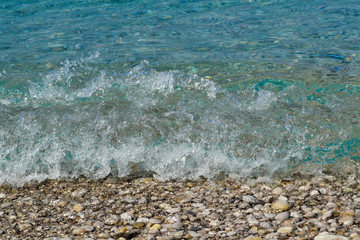 Wall Mural - square background image of calm turquoise sea on shingle beach