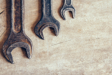 Different old wrenches on a wooden background and copy space. Top view