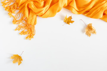 Wall Mural - Autumn cozy composition. Dried autumn leaves, yellow scarf on white background. Fall relax concept. Flat lay, top view, copy space