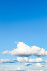 Wall Mural - low white clouds in blue sky in summer evening