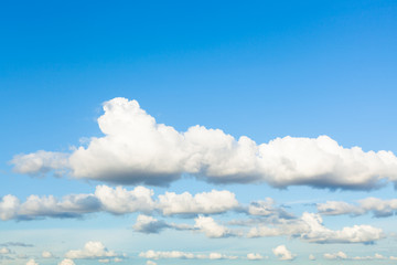 Canvas Print - chains of white and gray clouds in sky in evening