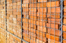 Background Texture-stacks Of Reclaimed Red Bricks In A Large Wire Cage With Shallow Depth Of Field