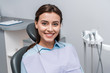 © LIGHTFIELD STUDIOS - beautiful woman sitting and smiling in dental clinic