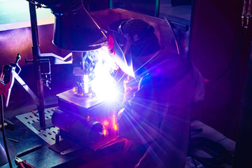 Wall Mural - Industrial production. Welding business. Welder at work. The workplace of the welder. Man welding metal parts. Protection of the worker when performing welding operations.