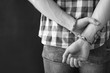 © New Africa - Criminal detained in handcuffs against dark background, space for text. Black and white effect