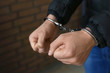 © New Africa - Man detained in handcuffs indoors, closeup view. Criminal law