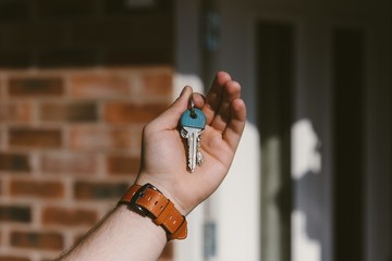 Wall Mural - Closeup of a person hand holding keys with a blurred background