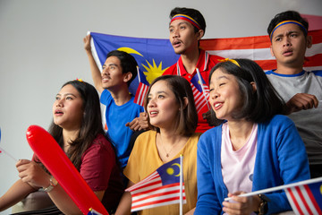 Wall Mural - malay group of people holding malaysia flag celebrating independence day