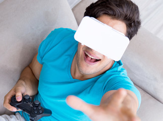 Young man wearing VR glasses relaxing on couch sofa