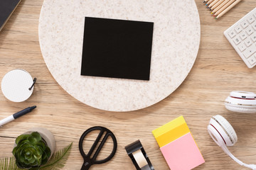 Poster - blank blackboard mock up on office desk table top view with stationery,notebook,plant on wooden table background.smart phone screen for display of design.business object flat lay