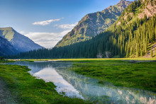 Idyllic Summer Landscape With Hiking Trail In The Mountains With Beautiful Fresh Green Mountain Pastures, River With Reflection And Forest. Terskey Alatoo Mountains, Tian-Shan, Karakol, Kyrgyzstan