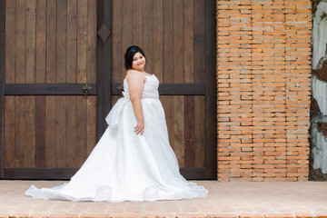 Happy Asian overweight model in beautiful bridal dress or white race wedding dress in many movement