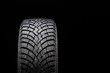 New winter studded tire, safety and premium quality. black background, close-up