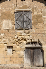 Wall Mural - Front wall of an old stone house in Saint Emilion. France.  St Emilion is one of the principal red wine areas of Bordeaux and very popular tourist destination.