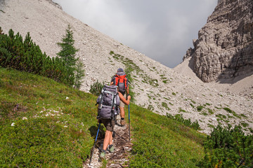 Wall Mural - some hikers walk along a mountain path.