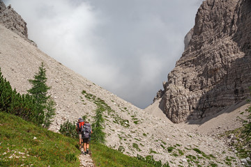 Wall Mural - some hikers walk along a mountain path.