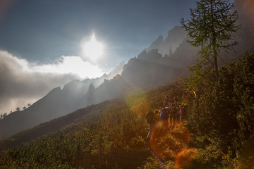 Wall Mural - some hikers go up a mountain path in the early hours of the day