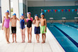 © Monkey Business - Portrait Of Children Standing On Edge Of Pool Waiting For Swimming Lesson