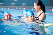 © Monkey Business - Female Coach In Water Giving Group Of Children Swimming Lesson In Indoor Pool