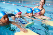 © Monkey Business - Female Coach In Water Giving Group Of Children Swimming Lesson In Indoor Pool