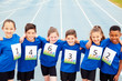 © Monkey Business - Portrait Of Children On Athletics Track Wearing Competitor Numbers On Sports Day
